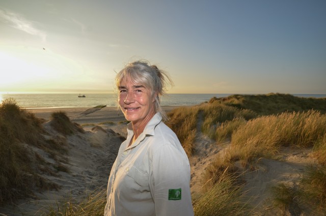 Portretfoto van Anke, in blouse van Staatsbosbeheer, op een duinovergang op Vlieland.